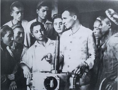 В Андижане: начальник сборочного цеха П.В. Артемьев знакомит молодых узбекских рабочих с продукцией завода. 1943 г.